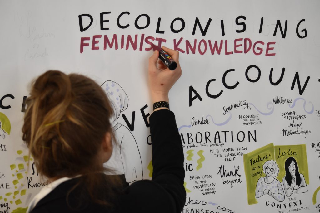 Words written on a whiteboard: Decolonising Feminist Knowledge