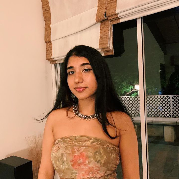 An image of Aarti in a flowery top and necklace