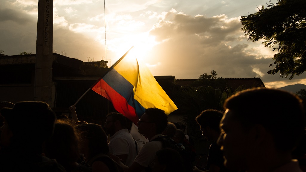 Colombian flag flying above the heads of people walking
