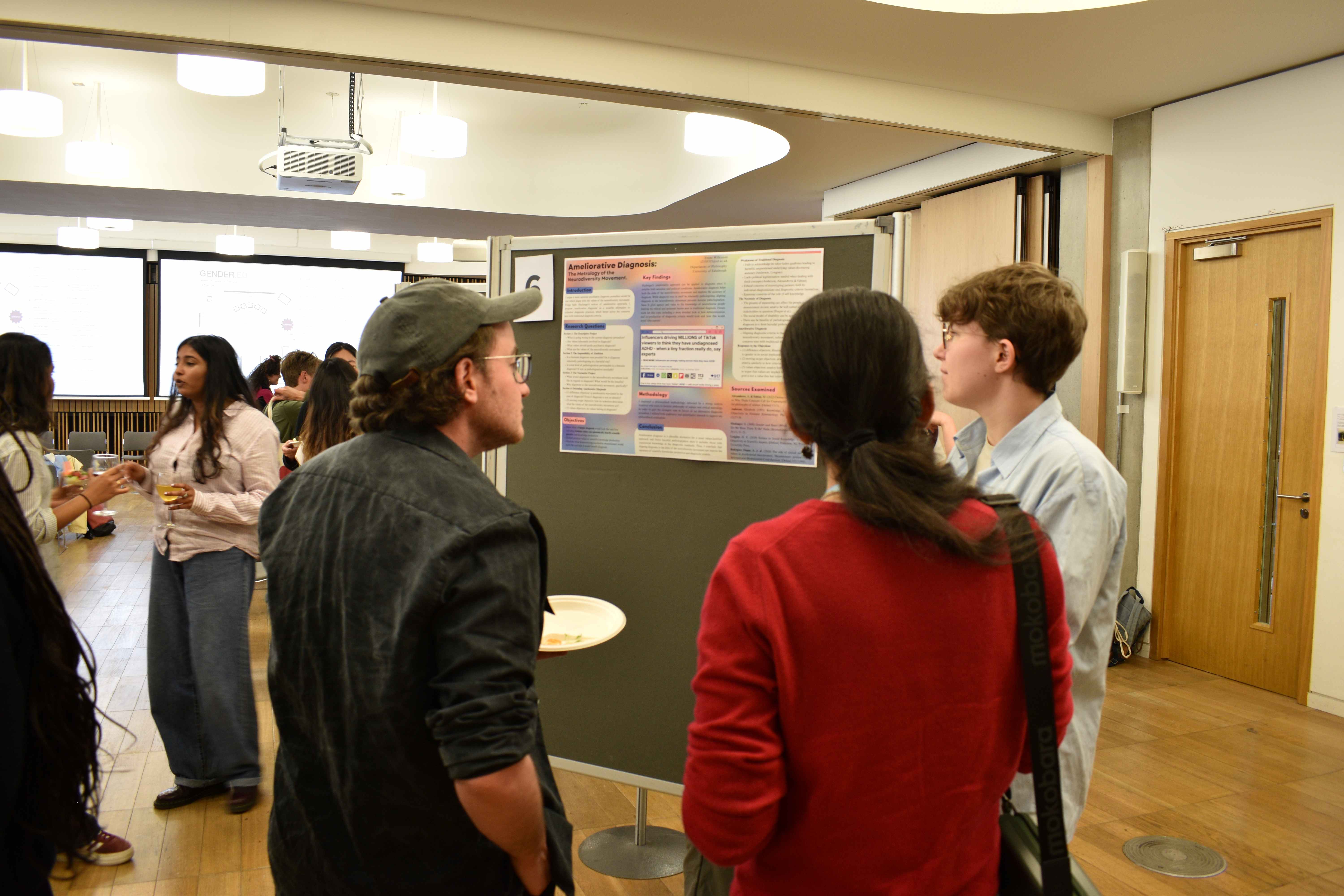 A group of people looking at and discussing one of the posters at the Annual research showcase.