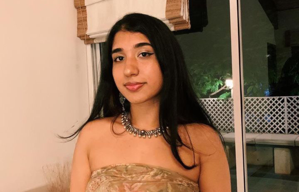 An image of Aarti in a flowery top and necklace