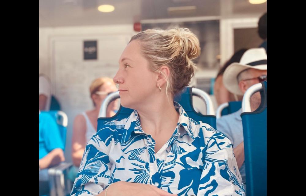 Photo of Rebecca Hewer in profile, sitting in a waiting area