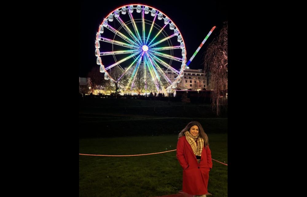 Photo of Aagoon in front of a ferris wheel at night.