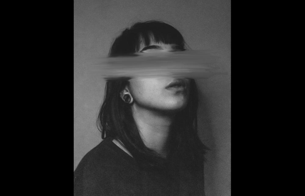 Black and white photograph of a woman with black hair, with a blurry rectangular panel over her eyes